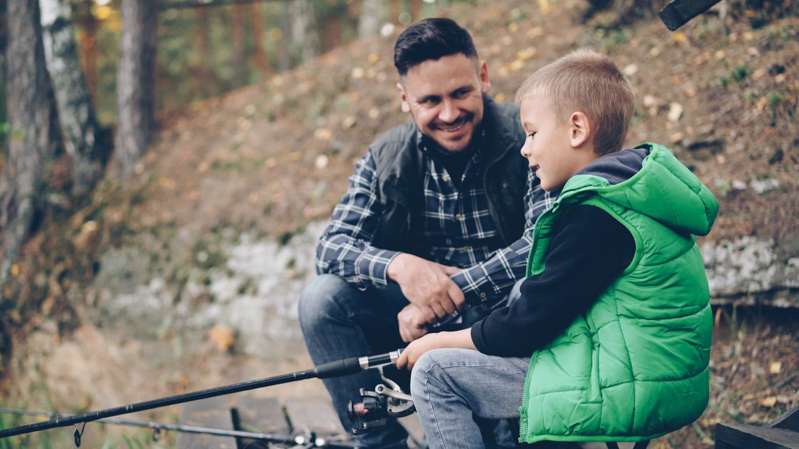 A father and son fishing together in an autumn forest