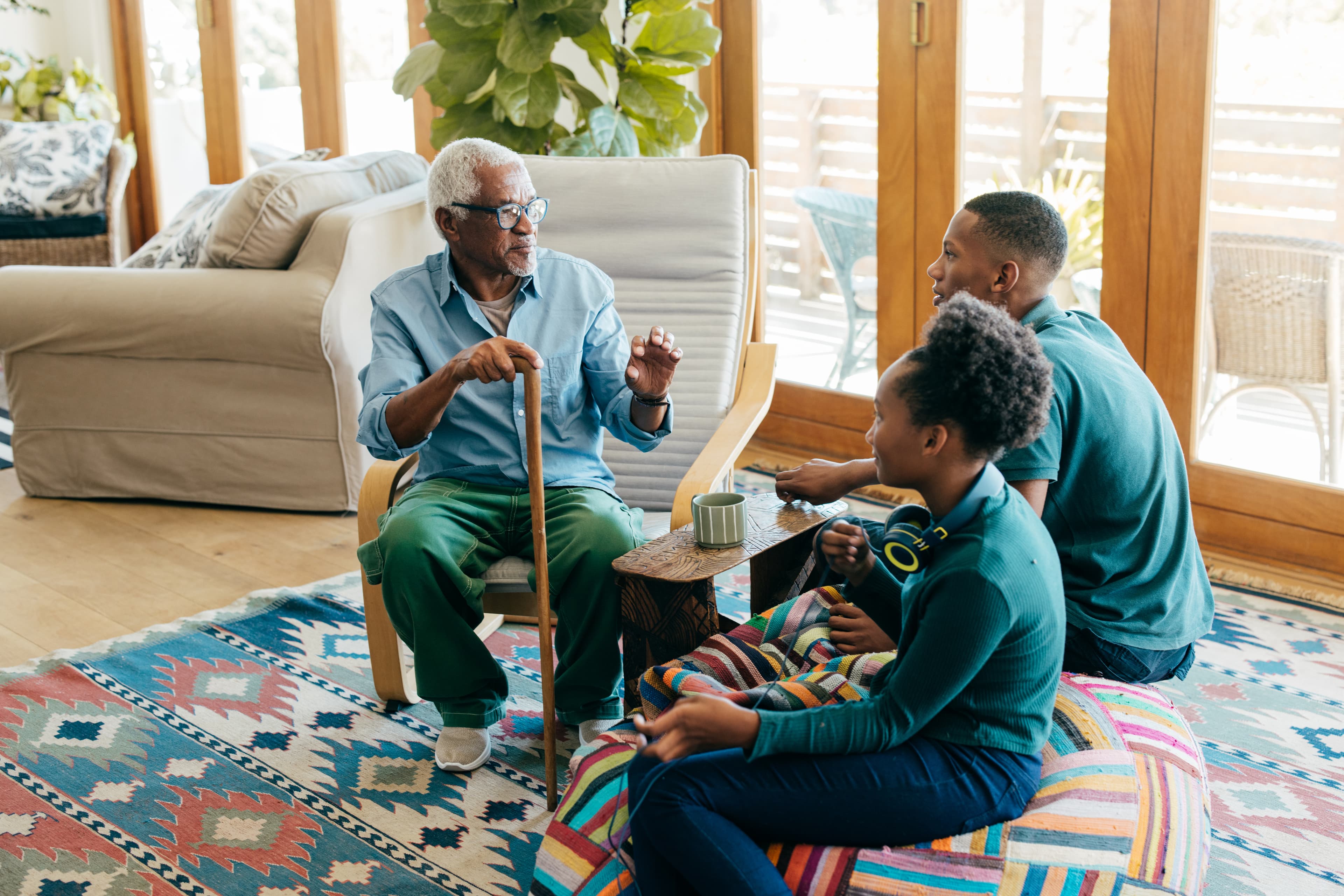 An older man telling a story to his grandchildren in a sunlit living room